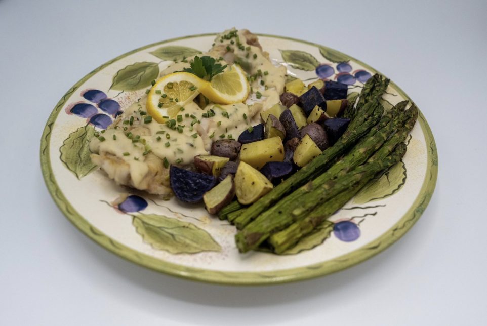 Walleye fillets plated with asparagus, potatoes and a twist of lemon.