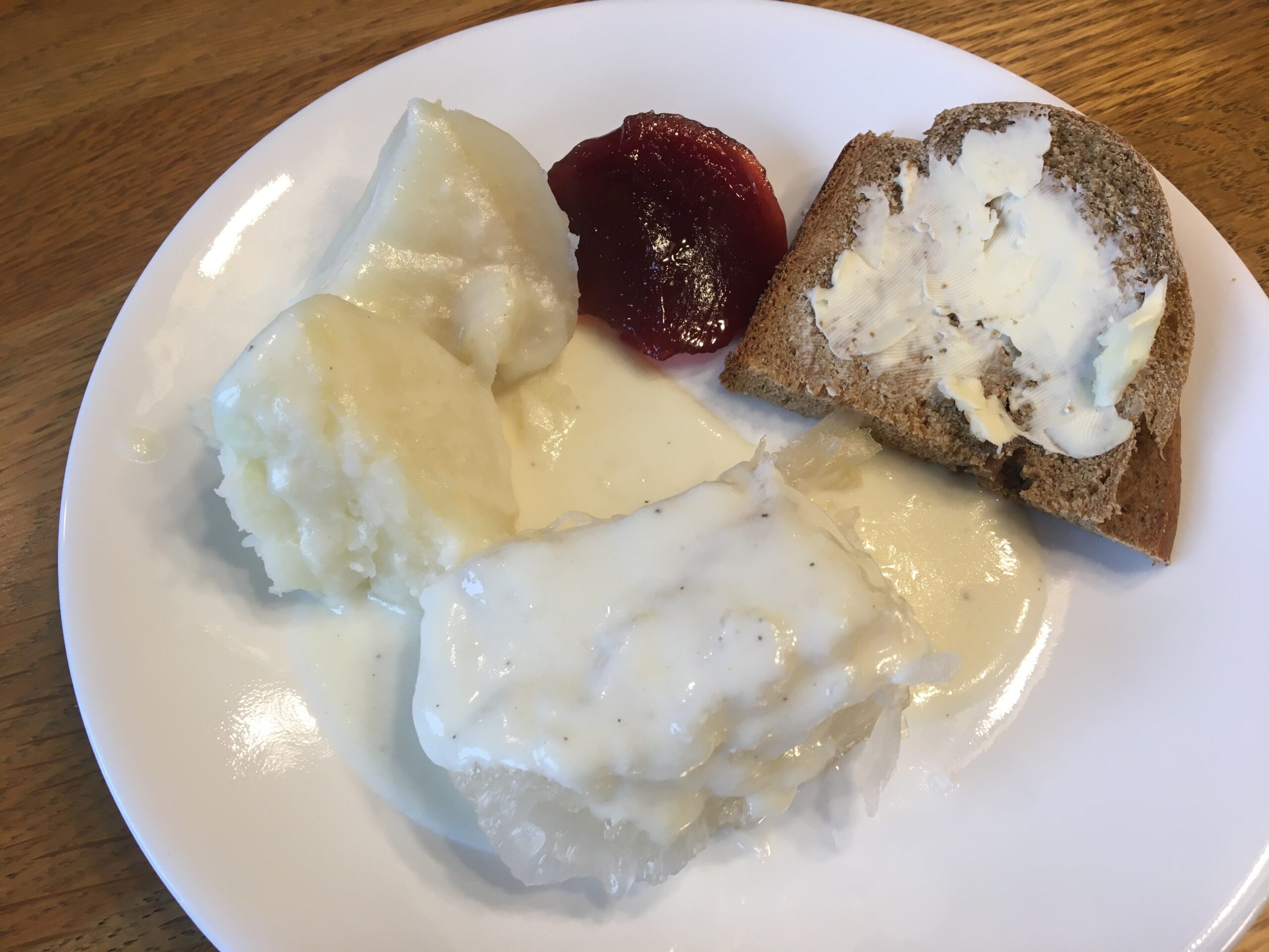 Lutefisk, potatoes in cream sauce paired with cranberry jelly and rye bread.