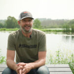 Grant Johnson sitting in front of a pond.
