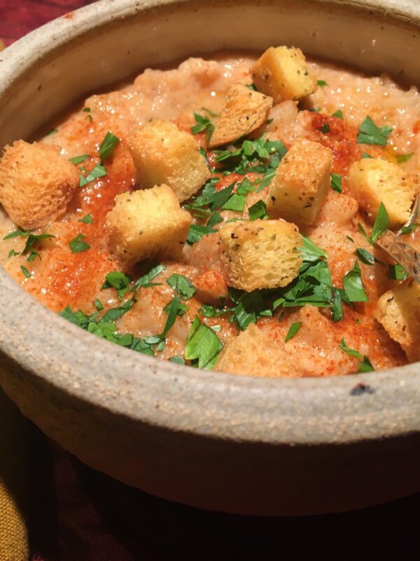 Bowl of fish chowder with parsley, croutons and paprika.
