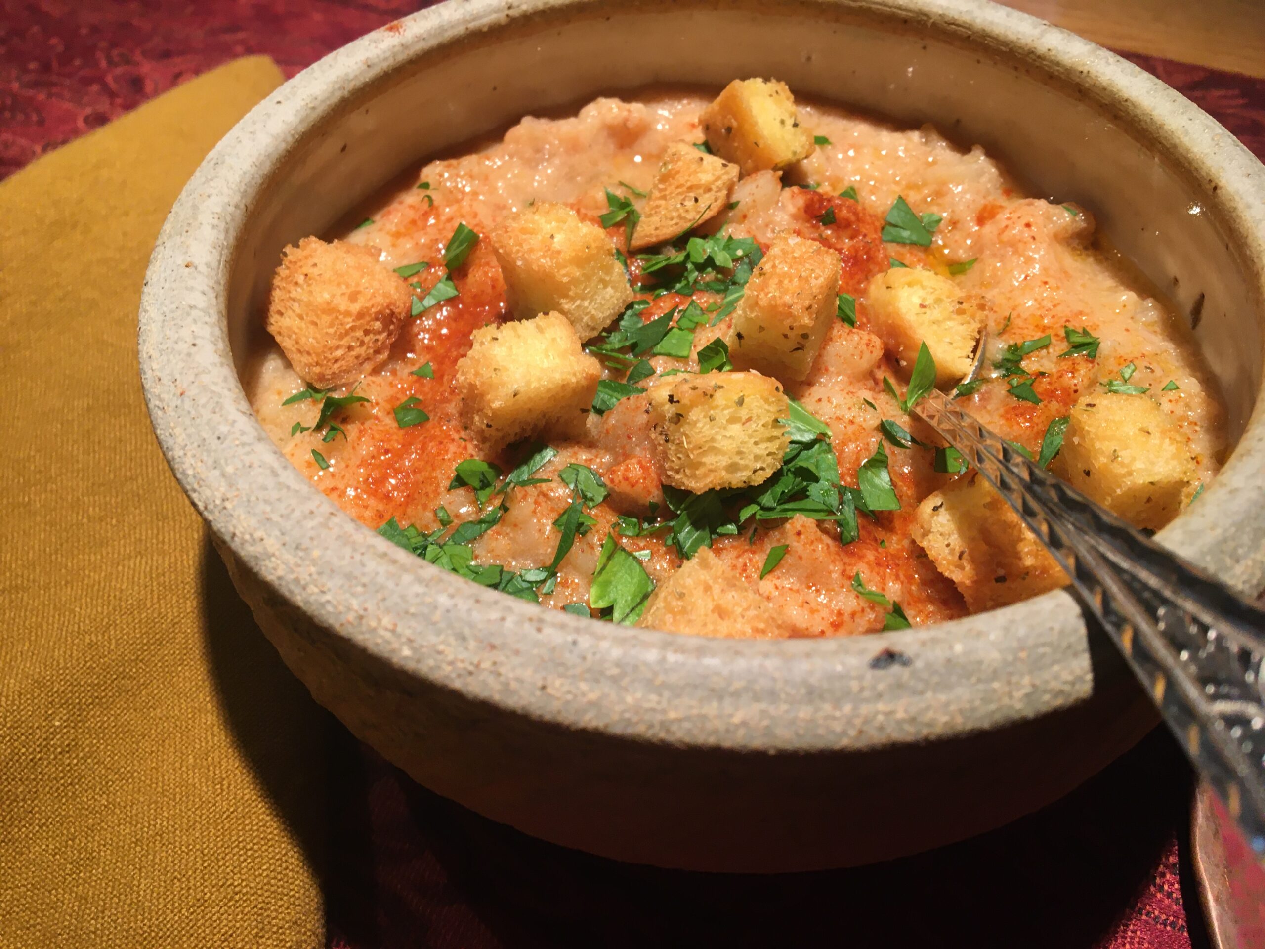 Bowl of fish chowder with parsley, croutons and paprika.